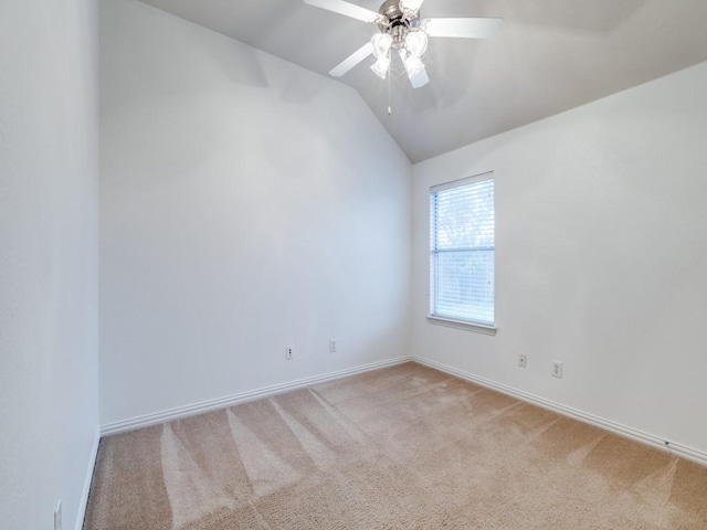 empty room featuring ceiling fan, light carpet, and vaulted ceiling