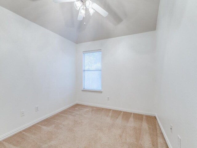 empty room with ceiling fan, light carpet, and vaulted ceiling