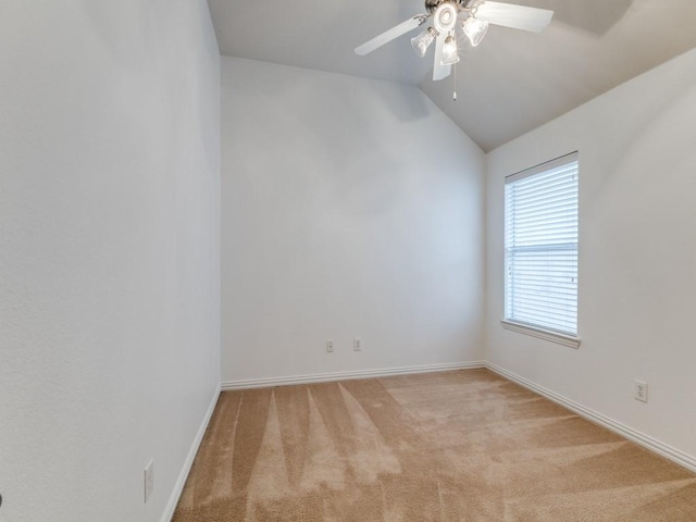 spare room with lofted ceiling, light colored carpet, ceiling fan, and baseboards