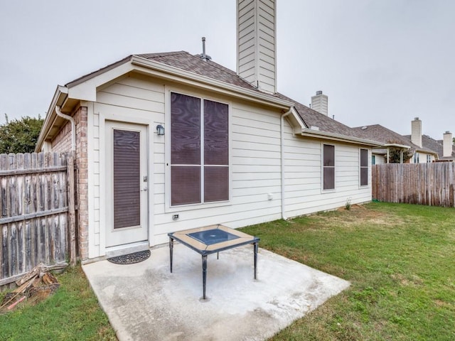 rear view of property with a lawn and a patio