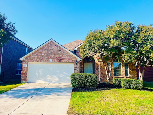 view of front facade featuring a front yard, driveway, an attached garage, and brick siding
