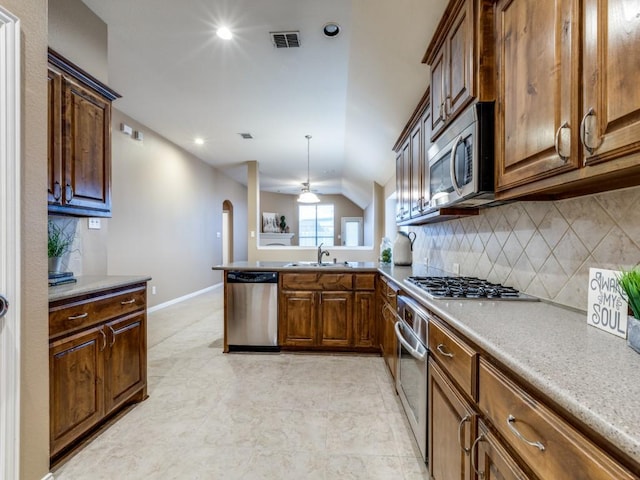 kitchen with a sink, stainless steel appliances, decorative backsplash, visible vents, and a peninsula
