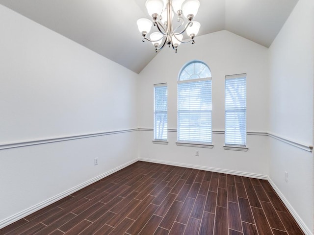 empty room with vaulted ceiling and a notable chandelier