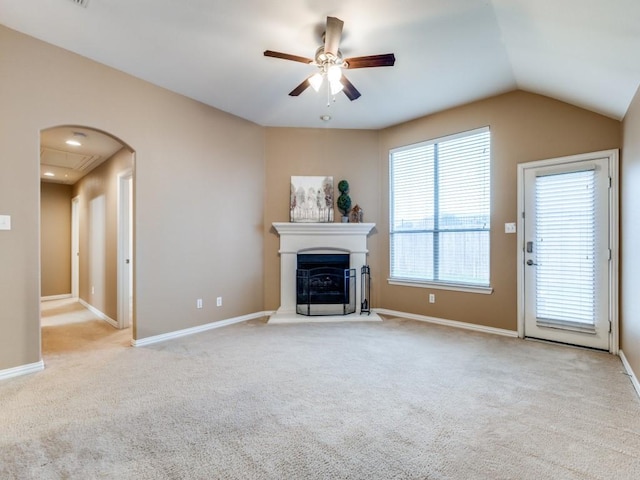 unfurnished living room with a fireplace with raised hearth, a ceiling fan, carpet floors, and baseboards