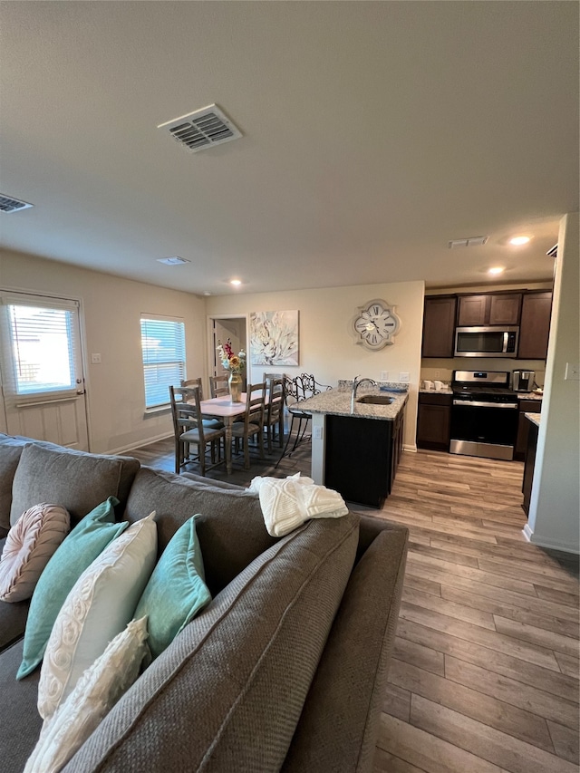 living room with sink and light hardwood / wood-style floors