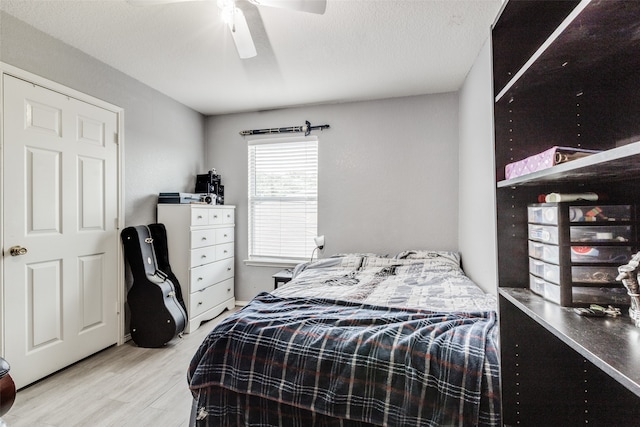 bedroom with a textured ceiling, hardwood / wood-style flooring, and ceiling fan