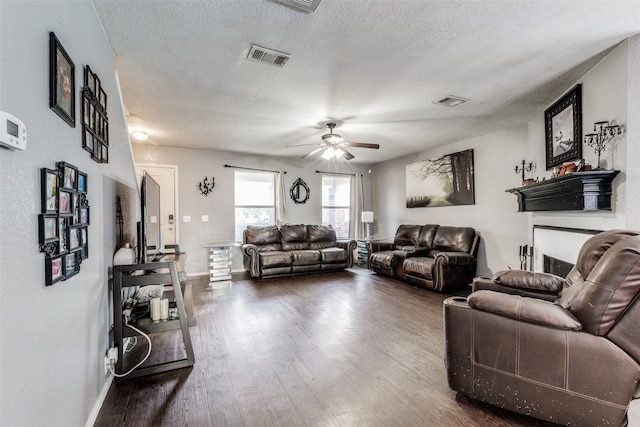 living room with ceiling fan, wood-type flooring, and a textured ceiling