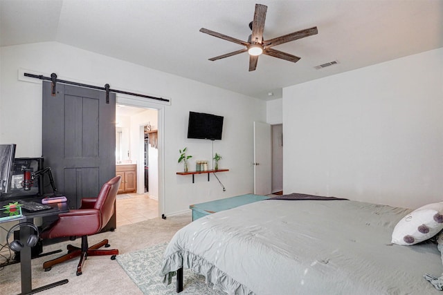 bedroom with lofted ceiling, light carpet, ceiling fan, a barn door, and connected bathroom