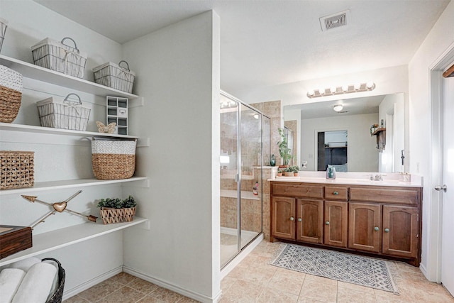 bathroom with tile patterned flooring, vanity, and a shower with shower door