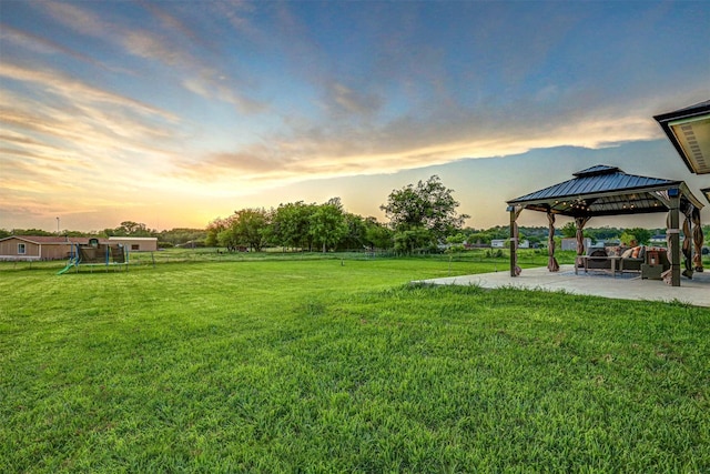 yard at dusk with a gazebo, a playground, and a patio