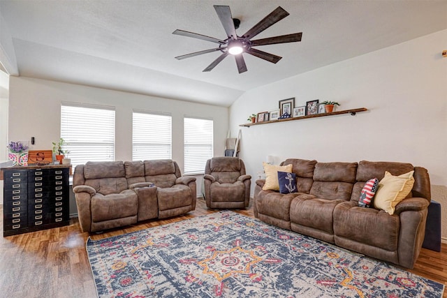 living room with ceiling fan, wood-type flooring, a wealth of natural light, and vaulted ceiling