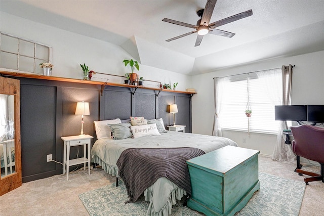 bedroom with ceiling fan, a raised ceiling, lofted ceiling, and light carpet