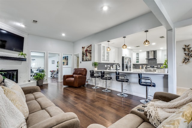 living room featuring a fireplace, dark hardwood / wood-style flooring, and sink