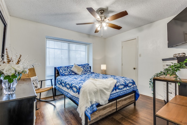 bedroom featuring ceiling fan, dark hardwood / wood-style floors, and a textured ceiling