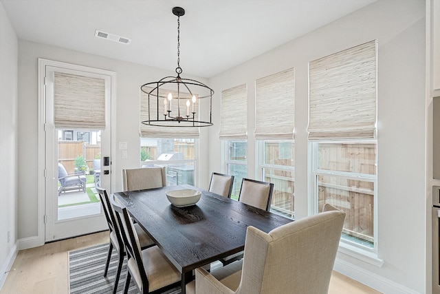 dining room featuring light wood-type flooring and a notable chandelier