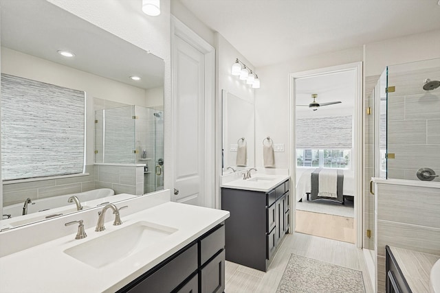 bathroom featuring shower with separate bathtub, hardwood / wood-style flooring, ceiling fan, and vanity