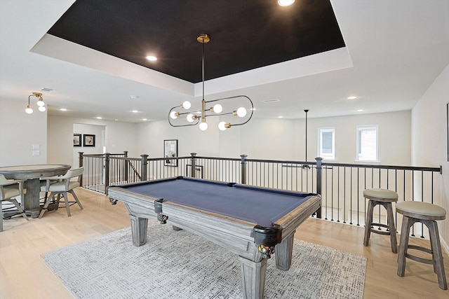 playroom featuring a chandelier, a tray ceiling, billiards, and light hardwood / wood-style flooring