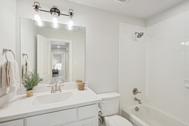 full bathroom featuring tiled shower / bath, toilet, and vanity