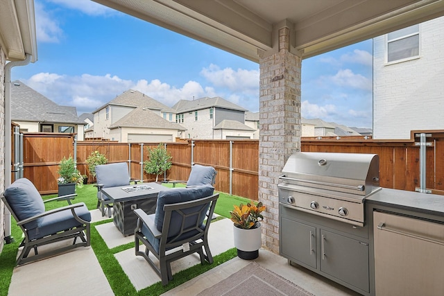 view of patio featuring area for grilling, a fire pit, and an outdoor kitchen