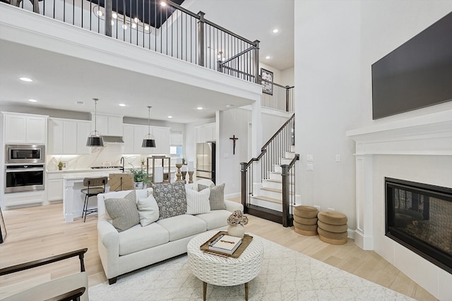 living room with a high ceiling and light hardwood / wood-style flooring