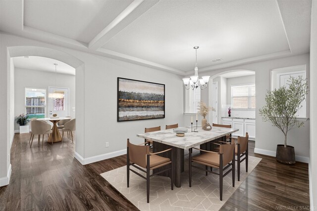 unfurnished dining area featuring dark hardwood / wood-style flooring and an inviting chandelier