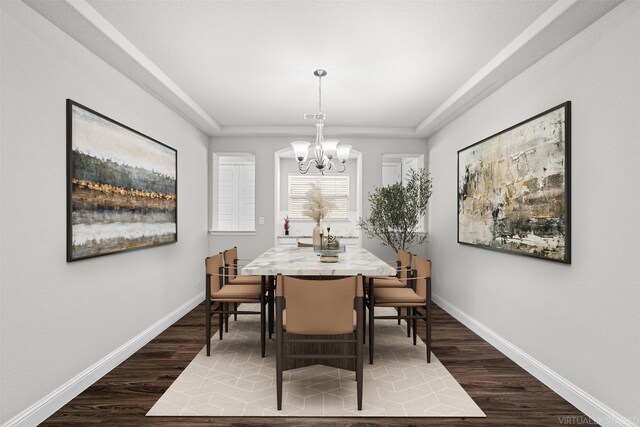 unfurnished dining area with a tray ceiling, dark hardwood / wood-style floors, and a chandelier