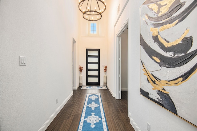 interior space featuring a notable chandelier, a high ceiling, and dark hardwood / wood-style floors