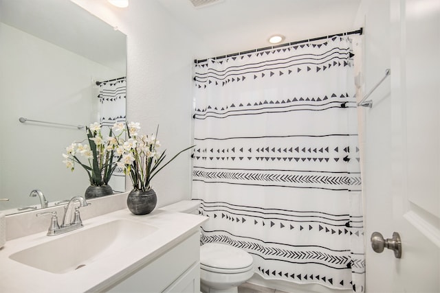 bathroom with vanity, a shower with shower curtain, and toilet