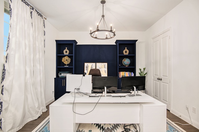 office area featuring dark wood-type flooring, built in features, and an inviting chandelier