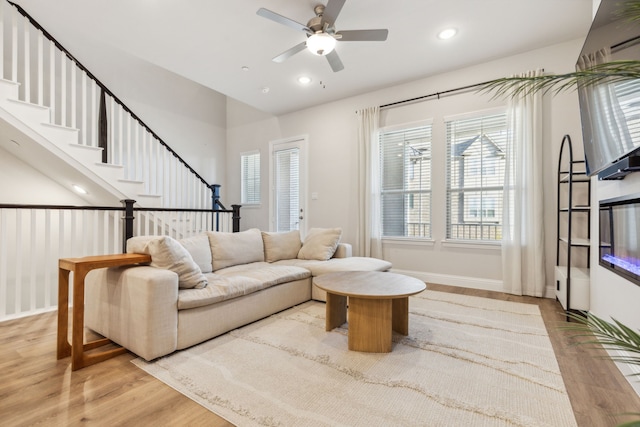 living room with ceiling fan and light hardwood / wood-style flooring