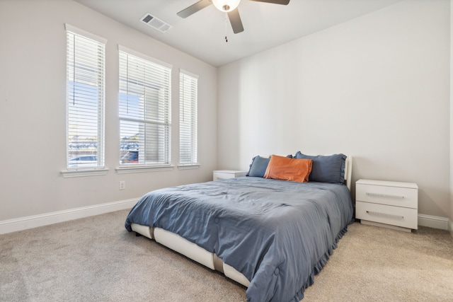 carpeted bedroom featuring ceiling fan and multiple windows