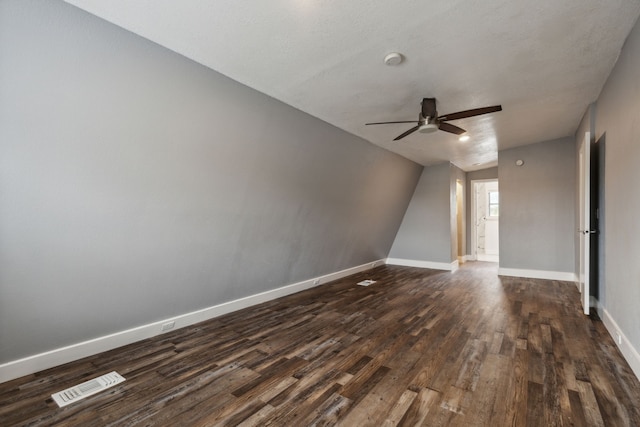 empty room featuring a textured ceiling, ceiling fan, dark hardwood / wood-style flooring, and lofted ceiling