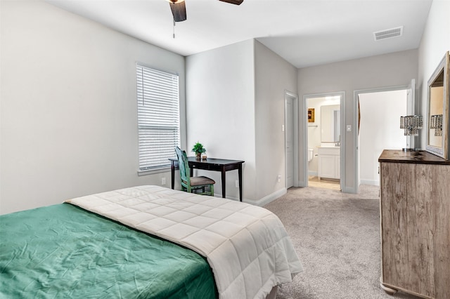 carpeted bedroom with ensuite bathroom and ceiling fan