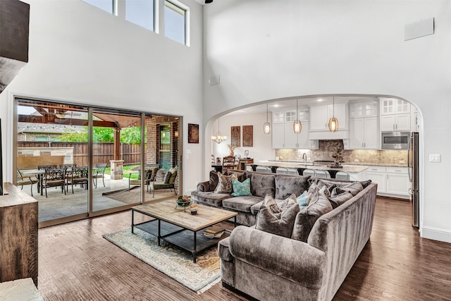 living room featuring a towering ceiling and dark hardwood / wood-style flooring