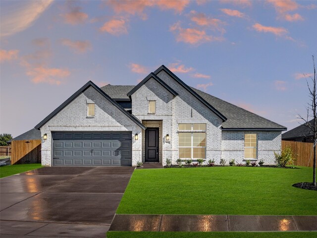 view of front of home with a yard and a garage