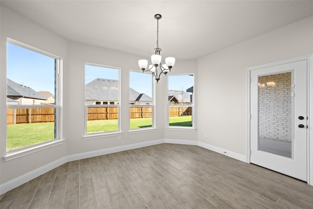 unfurnished dining area with a chandelier and a healthy amount of sunlight