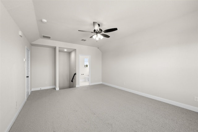 empty room featuring vaulted ceiling, light colored carpet, and ceiling fan