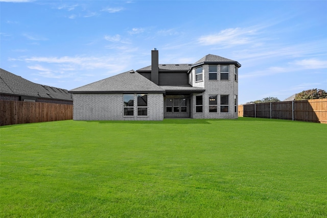 rear view of property featuring a lawn