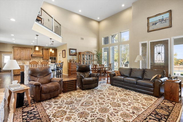 living room with a towering ceiling and light hardwood / wood-style floors