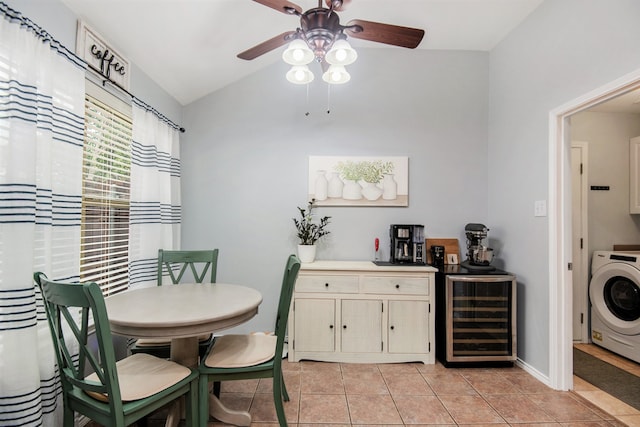 dining space featuring lofted ceiling, beverage cooler, light tile patterned floors, ceiling fan, and washer / clothes dryer