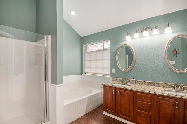 bathroom featuring vanity, shower with separate bathtub, vaulted ceiling, and wood-type flooring