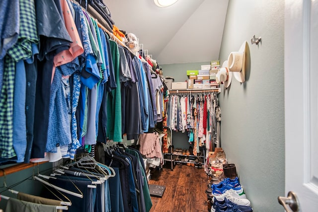 spacious closet featuring dark wood-type flooring and vaulted ceiling