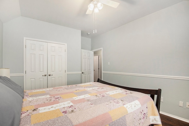 bedroom with dark wood-type flooring, ceiling fan, a closet, and vaulted ceiling