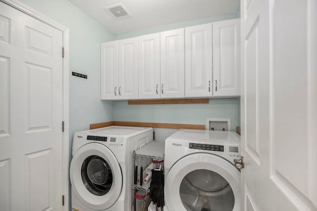 laundry room with cabinets and washing machine and clothes dryer