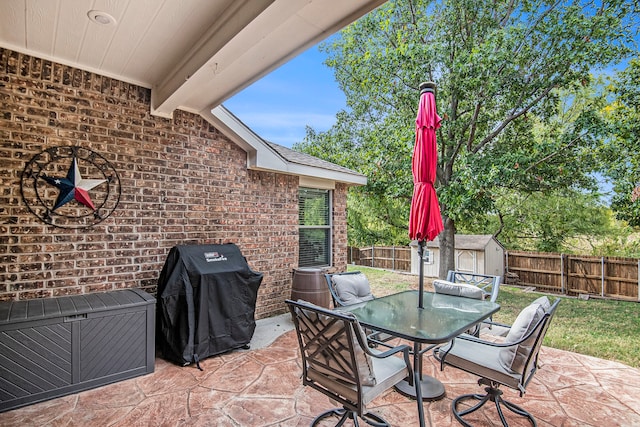 view of patio / terrace with a grill and a shed