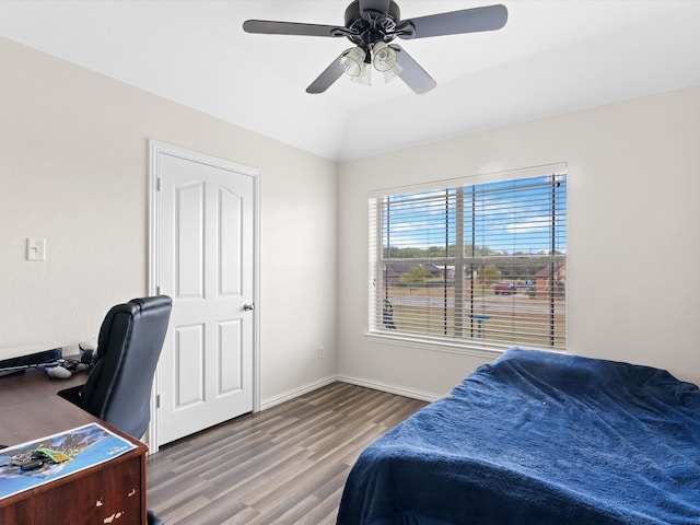 bedroom with ceiling fan, hardwood / wood-style flooring, and vaulted ceiling