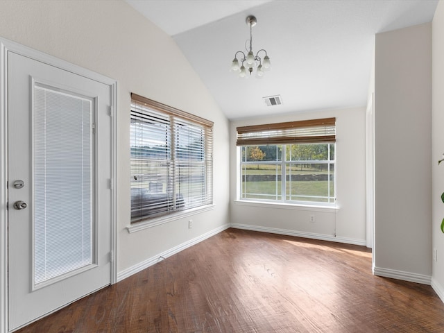 unfurnished dining area featuring lofted ceiling, plenty of natural light, and dark hardwood / wood-style floors