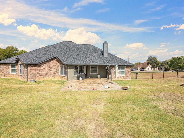 rear view of house with a patio and a lawn