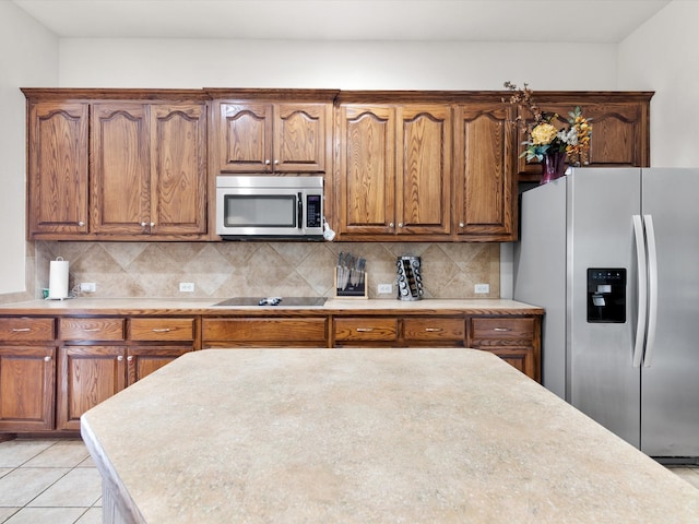 kitchen with stainless steel appliances, tasteful backsplash, and light tile patterned flooring