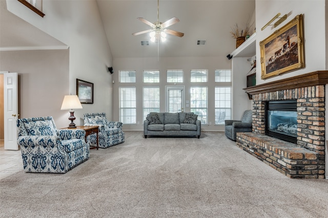 carpeted living room with crown molding, high vaulted ceiling, a fireplace, and ceiling fan